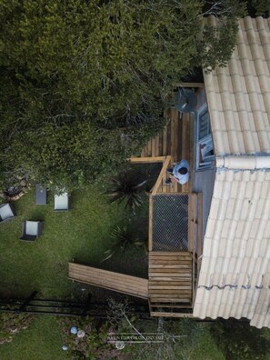 Una terraza en la azotea con piso de madera, un espacio de descanso pequeño y una sección cubierta.