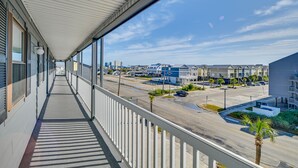 A covered balcony with a view of a parking lot and buildings. - Murrells Inlet Condo w/ Balcony & Pool: Near Pier! (Murrells Inlet)