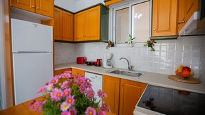 Eine Küche mit Holzausstattung, einem weißen Kühlschrank, einer Spüle und einem Herd.