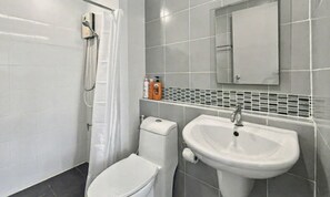 Un baño moderno con inodoro, lavabo y ducha.