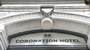 Une enseigne indiquant l’hôtel Coronation, avec le numéro 59.