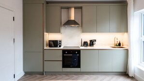 A compact kitchen with a built-in oven, microwave, and coffee maker.