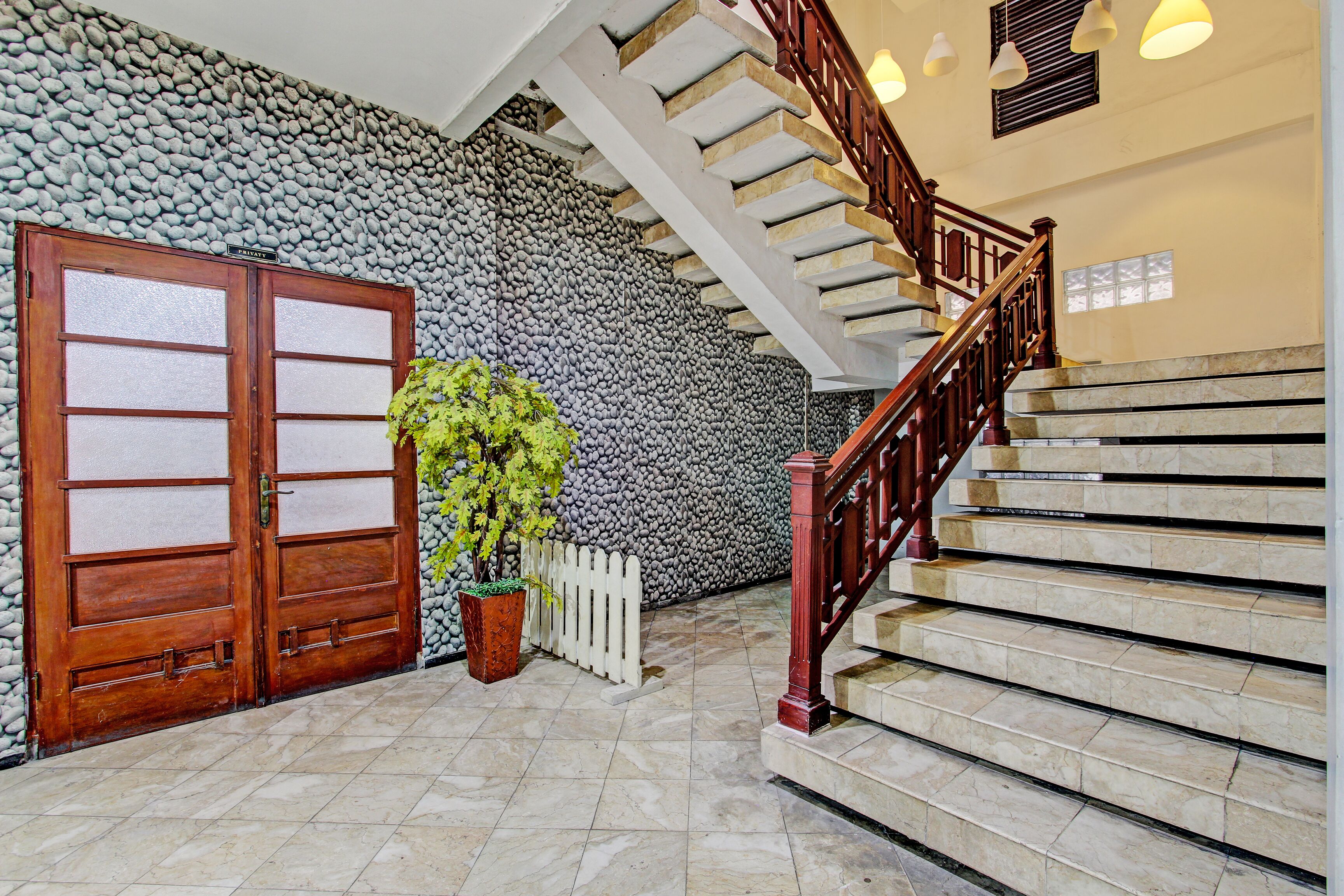 A staircase with a wooden handrail and a stone wall.