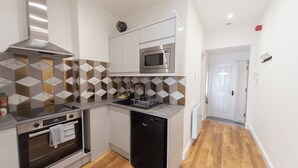A compact kitchen with a microwave, oven, and dishwasher. - Beautiful 7 bedroom Victorian home in Lancashire (Morecambe)
