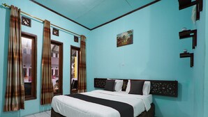 Ein Schlafzimmer mit einem großen Bett, Vorhängen, einem Gemälde und einem gefliesten Boden.