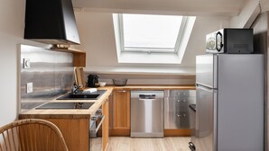 A compact kitchen with a skylight, stainless steel appliances, and wooden cabinetry. - Force 9 - Proche plage de Rochebonne (Saint-Malo)
