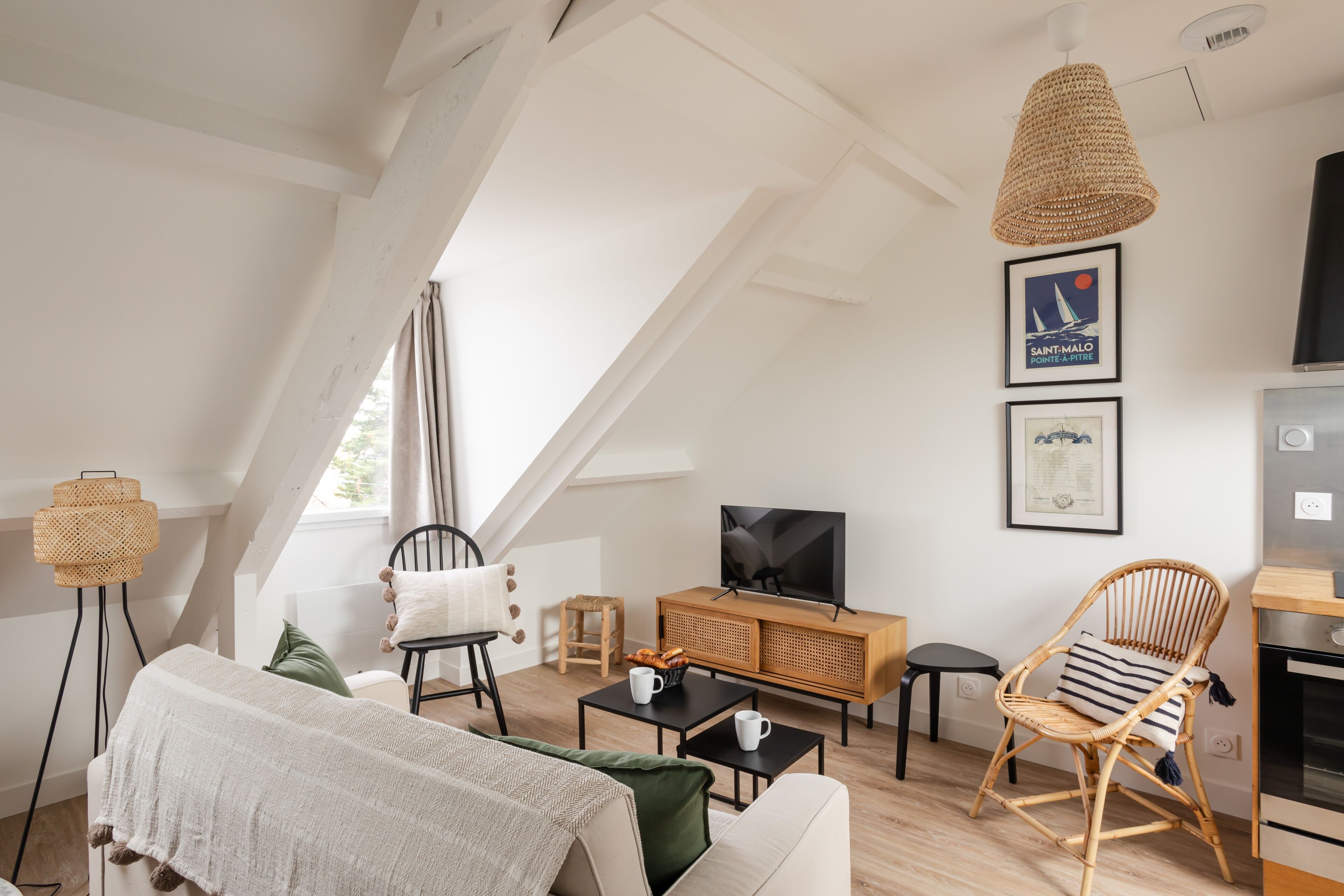Un espacio habitable moderno estilo loft, con techos altos, vigas a la vista y un ventanal grande.