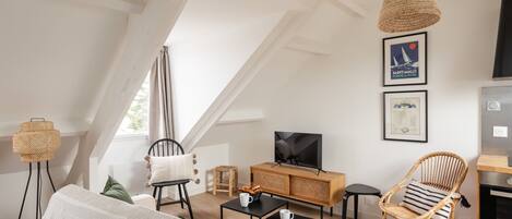 Un espacio habitable moderno estilo loft, con techos altos, vigas a la vista y un ventanal grande.