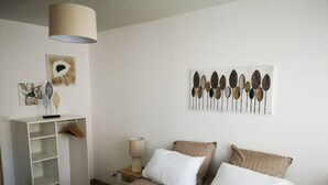 Quarto com cama, guarda-roupa, luminária e obras de arte na parede.