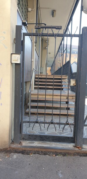 Ein Metallgitter mit einer Treppe, die zu einem Hauseingang führt.