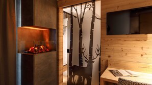 A modern interior with a fireplace, a wall-mounted TV, and a dining area.