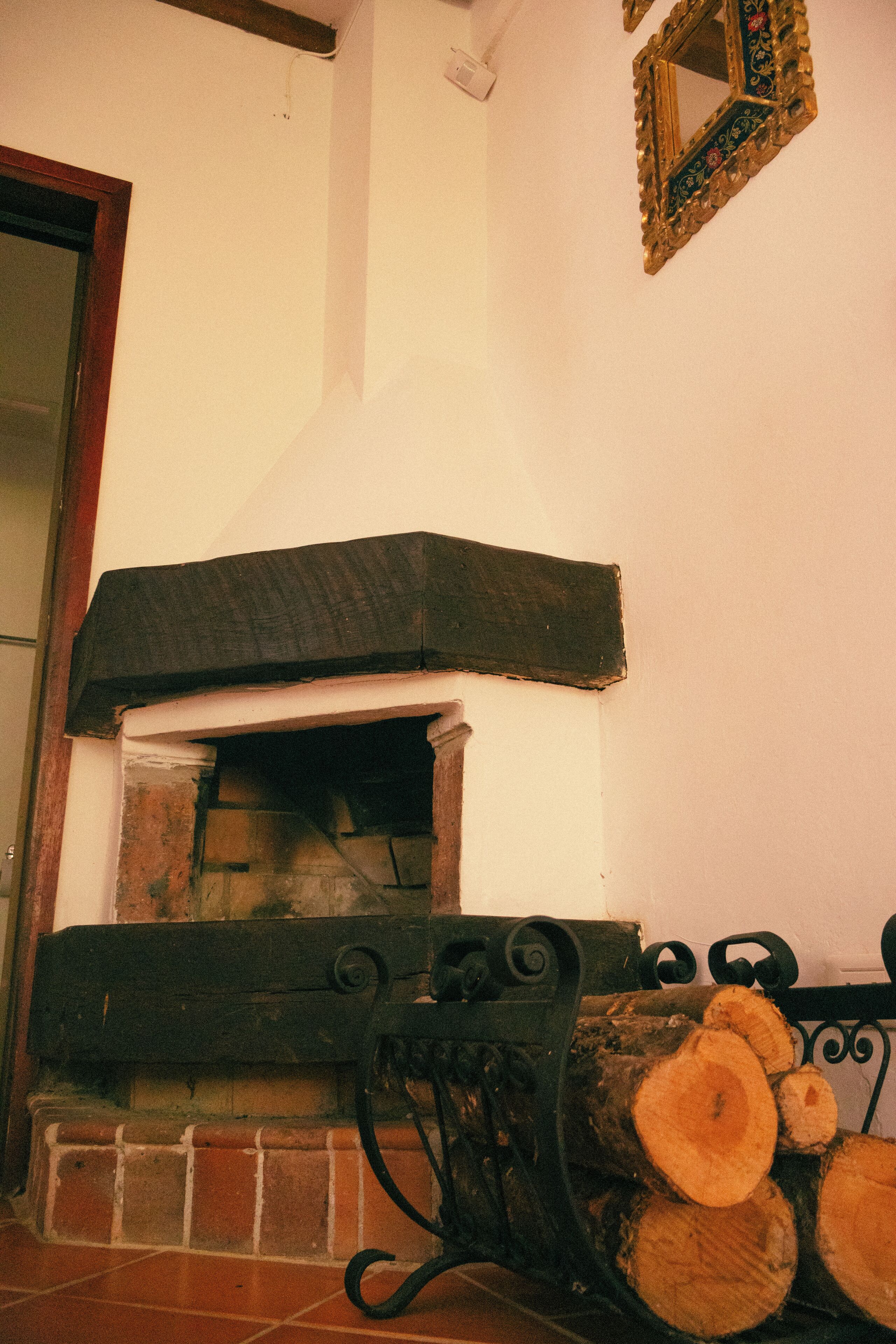 A fireplace with a brick surround, a mantel, and a log storage area.