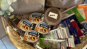 A gift basket with paper bags labeled "Paihuen Luxury Suites," containing various food items and a bottle of NeSquiK. - Paihuen Luxury Suites (Los Reartes)