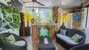 A cozy indoor seating area with wicker furniture, a central table, and decorative plants. - MIRADORES DEL PARAISO  (Puerto Triunfo)