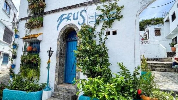 A white building with a blue door and the word "FEUS" painted on the wall. - MIRADORES DEL PARAISO  (Puerto Triunfo)