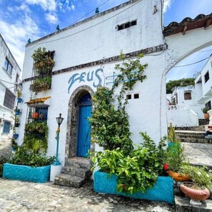 Ein weißes Gebäude mit einer blauen Tür und der Aufschrift 'FEUS' an der Wand.
