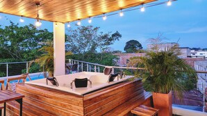 An outdoor bar area with wooden seating and a pool in the background. - MIRADORES DEL PARAISO  (Puerto Triunfo)