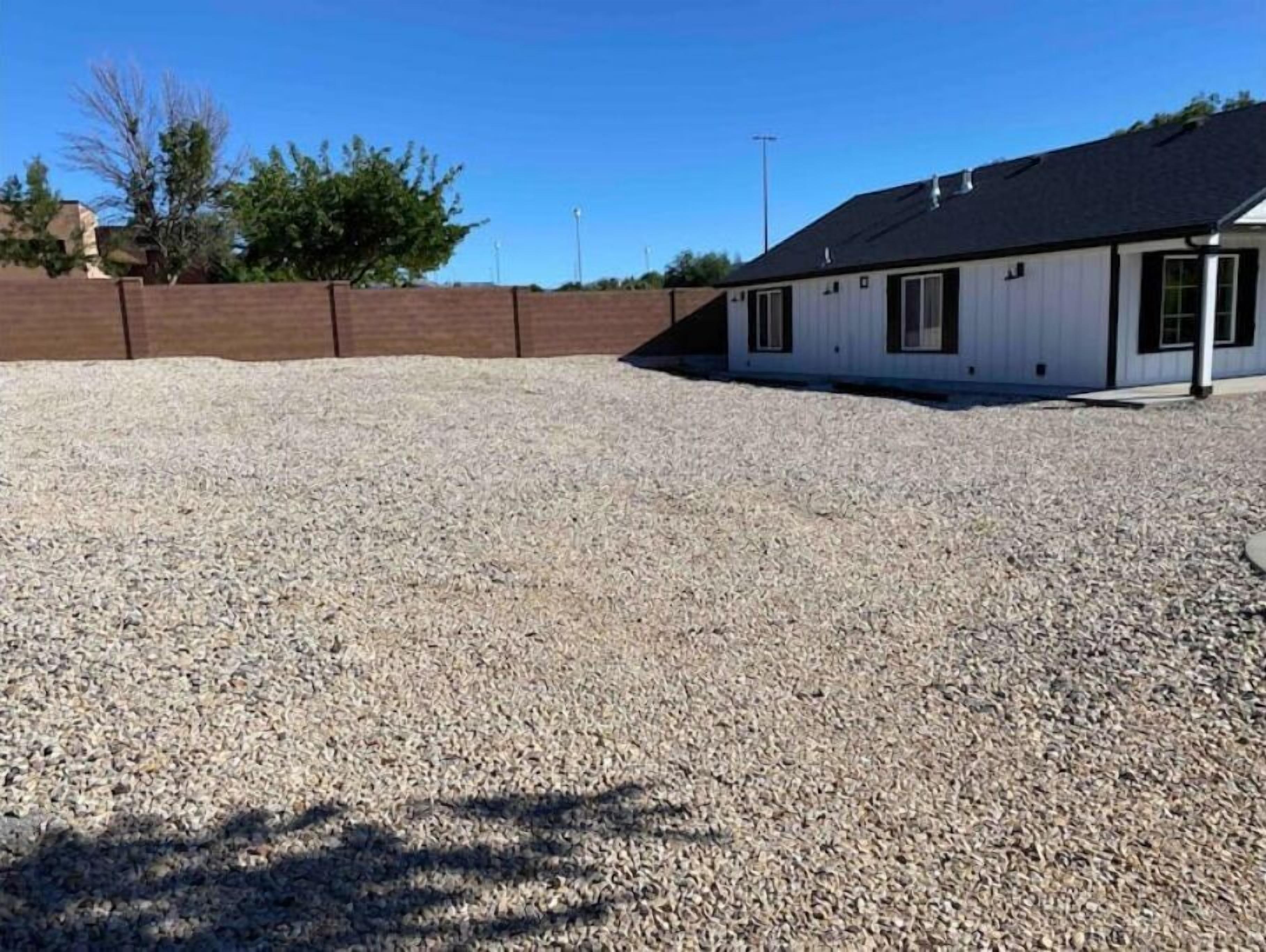 A building with a gravel driveway and a brick wall.