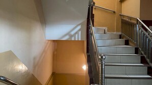 A staircase with metal railings and a handrail, leading to an upper floor. - Capital O 93285 Residence Hotel Syariah (Medan)