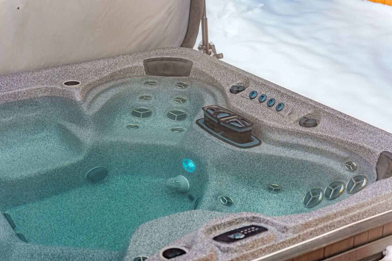 A hot tub with multiple jets and controls, surrounded by a stone-like exterior.