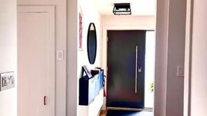 Un corridoio con pavimento in legno che conduce a una porta scura.
