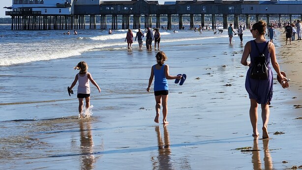 A beach with a pier in the background. - 5 Bedroom House Steps to the Beach (Old Orchard Beach)