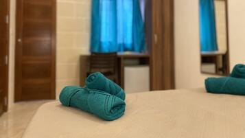 Ein Hotelzimmer mit einem Bett, einem Holzschrank, einem Spiegel und einem Fenster mit blauen Vorhängen.