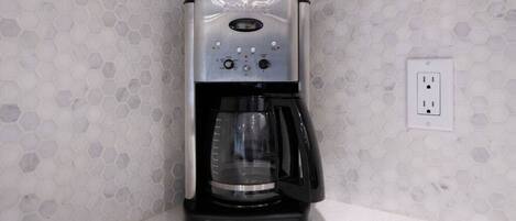 A Cuisinart coffee maker with a programmable interface, a built-in grinder, and a water filter.