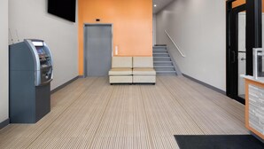 Ein Empfangsbereich mit Sitzgelegenheit, einer Treppe und einer Rezeption.