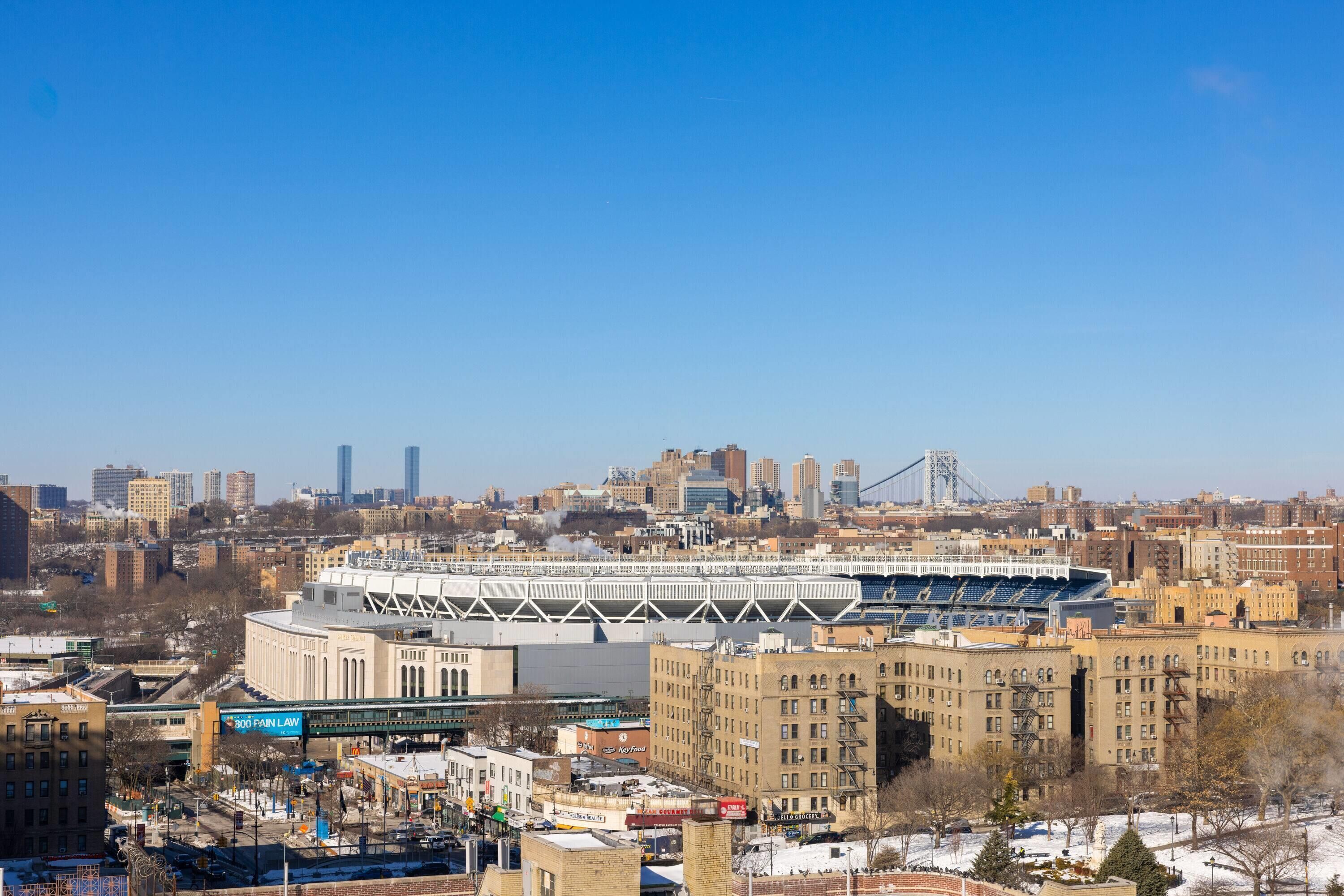 A cityscape with a large stadium, urban buildings, and a bridge in the background.