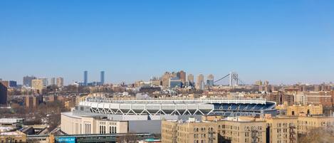 Une vue urbaine avec un grand stade, des bâtiments de la ville et un pont en arrière-plan.