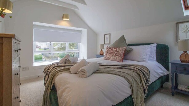 A bedroom with a large bed, a window, a nightstand, and a dresser. - Henry Bell 2 bed in Helensburgh Near Loch Lomond (Helensburgh)