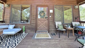 A wooden cabin with a porch, a door with a wreath, and a bench. - Stoney Creek | Peaceful Cabin, Couples Retreat (Overgaard)
