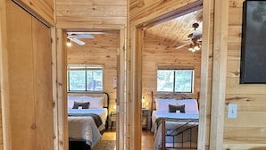 A wooden cabin with two bedrooms, each with a bed, bedside table, and window. - Stoney Creek | Peaceful Cabin, Couples Retreat (Overgaard)