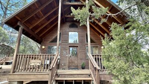 A wooden cabin with a porch, a front door, and a sign reading "Juniper Grove 2742". - Juniper Grove | Loft & Personal Hot Tub! (Overgaard)