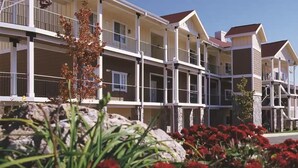 A multi-story hotel with balconies, a stone facade, and a clear sky. - Wyndham Vacation Resort! Serene · Clean · Fun! (Branson)