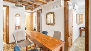 Un comedor con una mesa de madera, sillas y un espejo grande en la pared.
