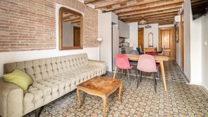 Una sala de estar acogedora con un sofá, una mesa de centro de madera y un comedor con sillas y una mesa.
