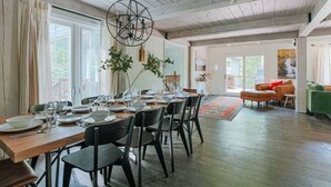 A dining area with a wooden table set for four, surrounded by chairs.