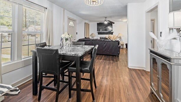 A modern living room with a dining area, a fireplace, and a kitchen area.