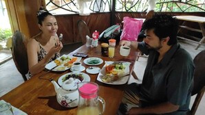 A wooden dining table with plates of food, a teapot, and a pitcher. - SACHA ÑAMPI ECOLODGE   (Parroquia Nuevo Rocafuerte)