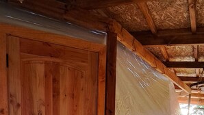 A wooden door and a white plastic barrier on a wooden deck.