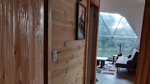 A wooden interior with a tented outdoor area, a painting, and a small table.