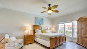 A bedroom with a bed, nightstands, a chair, a wardrobe, a ceiling fan, and a window with blinds. - St Augustine Poolside Oasis w/ Private Patio! (St. Augustine)
