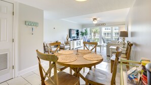 A dining area with a round wooden table, six wooden chairs, and woven placemats. - St Augustine Poolside Oasis w/ Private Patio! (St. Augustine)