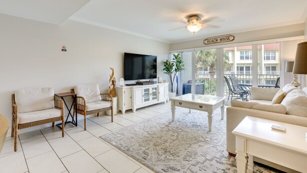 A living room with a television, two sofas, a coffee table, and a sign reading "BEACH HOUSE". - St Augustine Poolside Oasis w/ Private Patio! (St. Augustine)