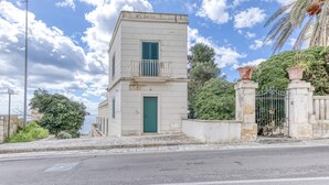A small, single-story building with a green door and a balcony. - SUITE VISTA MARE (Santa Cesarea Terme)