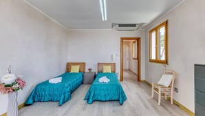 A hotel room with two single beds, a wooden chair, a desk, and a large window. - SUITE VISTA MARE (Santa Cesarea Terme)