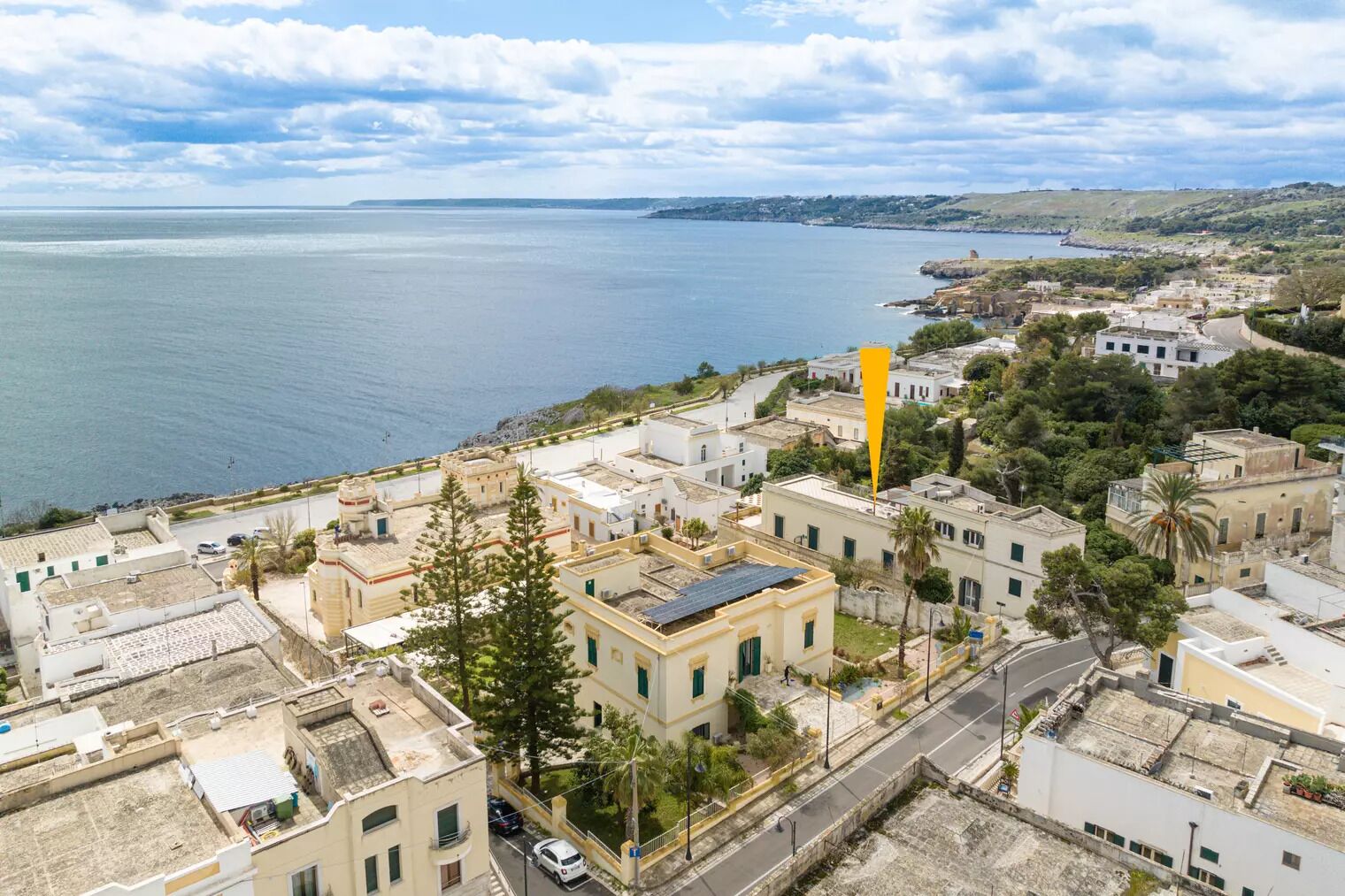 Vista aérea de un pueblo costero con edificios, una carretera y una masa de agua.