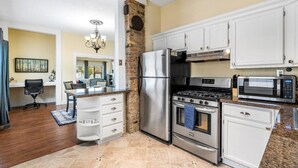 A kitchen with a refrigerator, stove, microwave, and white cabinets. - Quiet Home Near Downtown + Mountain Views (Salt Lake City)
